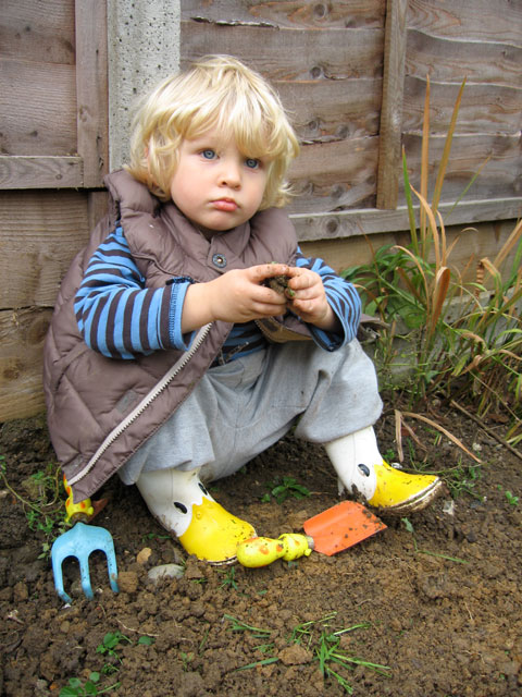 small boy sitting in the garden